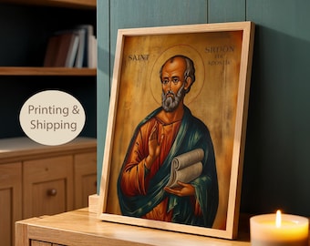 May include: Framed religious artwork featuring an illustration of Saint Simon the Apostle. The image has a gold background with a halo. The saint is depicted with a beard, wearing orange and green robes, and holding a scroll. The frame is made of light-colored wood.