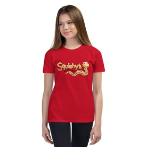 Peut inclure: T-shirt rouge pour enfant avec un serpent de dessin animé et le texte "Squishy's Reptiles" en orange et noir.