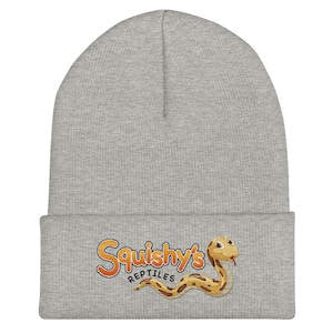 May include: Grey beanie with a logo of a cartoon snake and the text "Squishy's Reptiles" in orange and yellow.