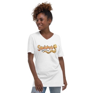 Könnte beinhalten: Weißes V-Ausschnitt-T-Shirt mit einer Grafik einer Cartoon-Schlange und dem Text "Squishy's Reptiles".
