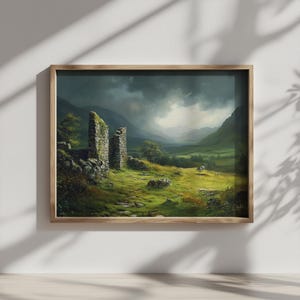 May include: A framed landscape painting shows a ruined stone structure in a green field, with mountains under a stormy sky. The artwork is presented in a wooden frame.
