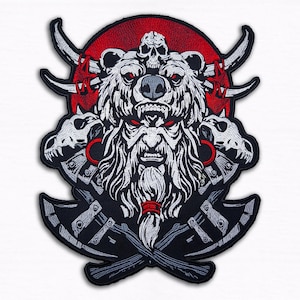 May include: Embroidered patch featuring a fierce bear with a skull on its head, horns, and axes. The design incorporates a red background and white and black details. The patch is a bold, detailed emblem.