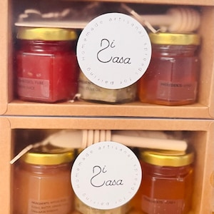 May include: A gift box set of four small glass jars filled with different spreads. The jars have gold lids and are labelled with a white circle sticker that says "Di Casa" and "Homemade Artisanal Spreads".