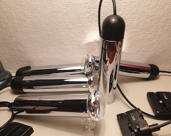May include: A set of four chrome and black track lighting fixtures with black cords and connectors. The fixtures are designed to be mounted on a track system.