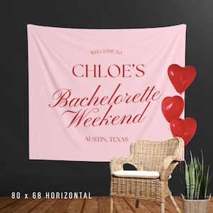 Pu&ograve; includere: Un banner rosa con testo rosso "WELCOME TO CHLOE'S Bachelorette Weekend AUSTIN, TEXAS". Tre palloncini rossi a forma di cuore sono a destra. Una sedia in vimini e una pianta in vaso sono davanti a uno sfondo scuro. Il banner misura 203 x 173 cm.
