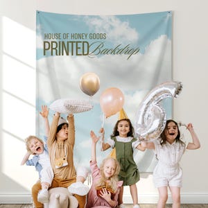 May include: A printed backdrop with a sky and cloud design, with the text "HOUSE OF HONEY GOODS PRINTED Backdrop". Children are holding balloons and a number 6 balloon. The children are smiling and appear to be celebrating.