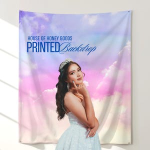 May include: A printed backdrop with a sky-themed design featuring a woman in a white dress and a tiara. The backdrop has the text "HOUSE OF HONEY GOODS" and "PRINTED Backdrop" in blue.