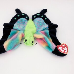May include: A green and multi-colored butterfly plush toy with black wings and a Ty tag.