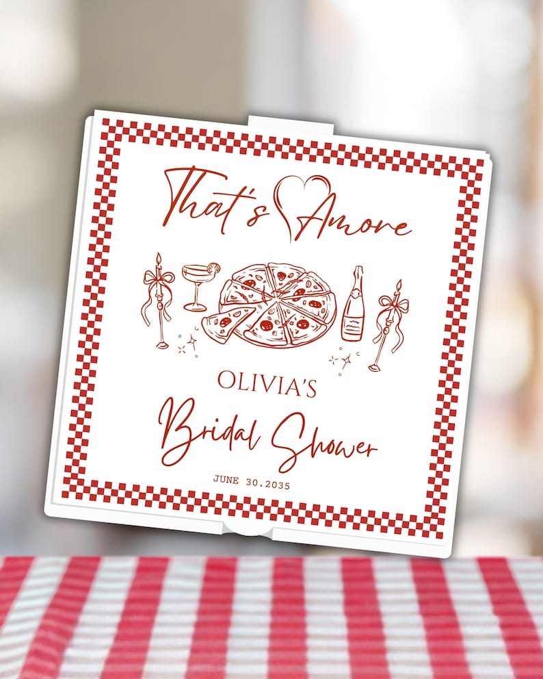 May include: A square white pizza box with a red checkered border. The lid features red line art of a pizza, a cocktail, a bottle, and two candles. Text reads: That's Amore, OLIVIA'S Bridal Shower, and the date JUNE 30, 2035, in red lettering.