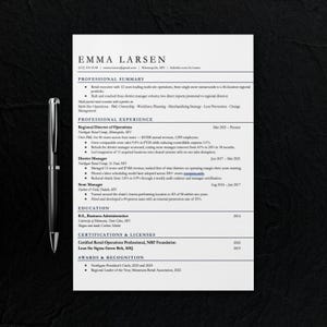May include: A professional resume template for Emma Larsen featuring sections for professional summary, experience, education, certifications, and awards, accompanied by a sleek black ballpoint pen positioned vertically on the left side.