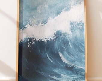 May include: A framed art print featuring a dynamic depiction of a breaking ocean wave. The artwork showcases shades of deep blue and white, capturing the movement and power of the sea. The print is encased in a natural wood frame.