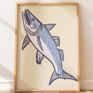 Pode incluir: Uma impressão de arte de parede emoldurada com uma ilustração estilizada de um peixe em tons de azul e roxo escuro sobre um fundo creme claro. O peixe é retratado na vertical com a boca aberta, dentro de uma moldura de madeira clara.