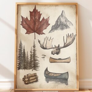 May include: A framed wall art print featuring a collection of nature-themed illustrations including a large red maple leaf, a mountain peak, a moose head with antlers, a cluster of pine trees, a stack of logs, and two canoes on a light background.