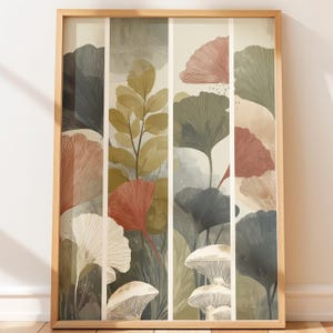 May include: A framed art print featuring a botanical illustration. The artwork showcases stylized ginkgo leaves and mushrooms in shades of red, gray, and green, set against a neutral background. The print is encased in a light brown wooden frame.