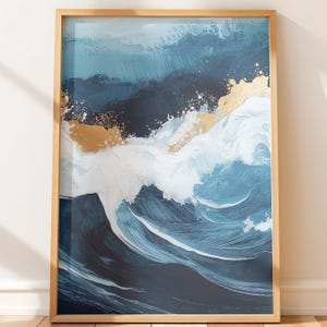 Puede incluir: Impresión artística abstracta que representa una ola oceánica dinámica en tonos azules, blancos y dorados. La obra de arte está enmarcada en un marco de madera natural, agregando un toque de calidez a la paleta de colores fríos. La pintura evoca movimiento.
