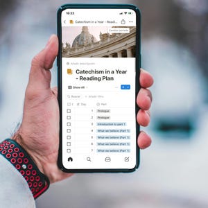 May include: A smartphone screen displaying a reading plan for a Catechism in a Year. The plan includes a list of daily readings with titles like "Prologue" and "What we believe (Part 1)".