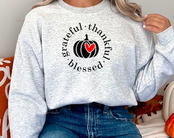 May include: A gray sweatshirt with a black and red pumpkin graphic and the text "grateful. thankful. blessed."
