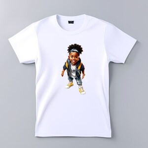 May include: White t-shirt with a cartoon illustration of a young boy wearing a black jacket, a yellow shirt, a black baseball cap, and blue jeans. The boy is smiling and looking at the camera.