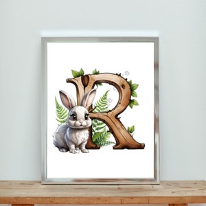May include: A white rabbit sits in front of a wooden letter R with green leaves. The letter is stylized to look like a tree trunk with bark and branches.
