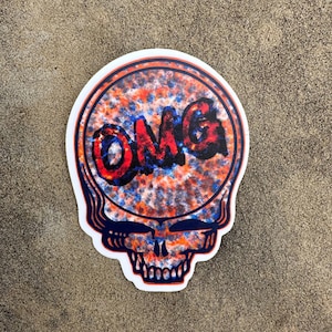 May include: A sticker with a colorful, psychedelic design featuring a skull with the word "OMG" inside. The skull is outlined in black and has a blue, orange, and red color scheme.
