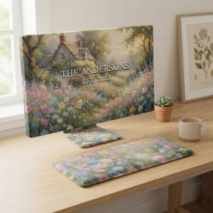May include: A computer monitor and keyboard wrist rest set featuring a printed landscape of a cottage surrounded by a colorful wildflower garden. The text THE ANDERSONS EST. 2023 is printed in white across the center of the monitor screen display.