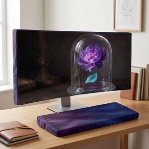 Könnte beinhalten: Ein Computermonitor und eine passende Tastatur-Handballenauflage mit einem dunkelvioletten und schwarzen Farbverlauf. Der Bildschirm zeigt eine digitale Illustration einer leuchtend violetten Blume in einer Glasglocke auf dunklem Grund.
