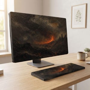 May include: A computer monitor and a matching keyboard skin featuring a dark, dramatic volcanic landscape. The screen displays a textured, stormy sky with glowing orange lava flows over rugged, dark terrain, creating a cohesive, moody aesthetic.