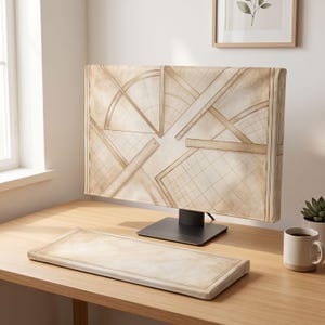 Puede incluir: Una funda para monitor de ordenador y un reposamuñecas para teclado a juego con un diseño de pergamino vintage que presenta líneas geométricas de dibujo, transportadores y reglas en tonos beige y marrón claro.