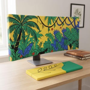 Pode incluir: Uma capa para monitor de computador e um apoio de pulso para teclado a condizer. A capa do monitor apresenta um fundo amarelo vibrante com um padrão de selva densa de folhas de palmeira verdes, folhagem azul e finas vinhas pretas. O apoio é amarelo e verde.