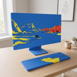Könnte beinhalten: Ein blauer Computermonitor und eine passende Tastatur-Handballenauflage mit einer grafischen Landschaftsillustration. Das Design zeigt gelbe und rote Berge, einen blauen Fluss und schwarze Bärensilhouetten auf blauem Grund.