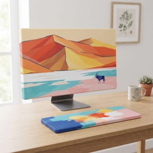Può includere: Una copertura per monitor di computer con un paesaggio desertico geometrico con dune arancioni, gialle e rosse, uno specchio d'acqua blu e un piccolo orice, abbinata a un poggiapolsi rettangolare per tastiera con un design astratto a macchie.