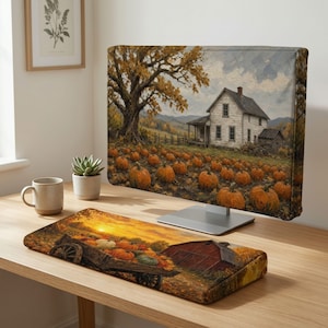Könnte beinhalten: Eine Computermonitor-Abdeckung und eine passende Tastatur-Handballenauflage mit einer herbstlichen Ernteszene. Die Monitorabdeckung zeigt ein weißes Bauernhaus, einen großen Baum und ein Kürbisfeld. Die Auflage zeigt einen Holzwagen.