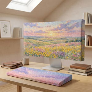 Op de afbeelding: Een computermonitorhoes en bijpassende toetsenbordpolssteun met een impressionistisch olieverfschilderij van een glooiende weide vol gele en paarse wilde bloemen onder een zachte roze, oranje en blauwe zonsonderganghemel met dikke penseelstreken.