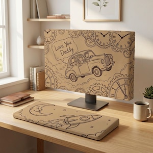 Op de afbeelding: Een beige computermonitorhoes en bijpassende toetsenbordpolssteun met zwarte lijntekeningen. De monitorhoes toont een vintage auto, tandwielen en een tekstballon met de tekst Love You Daddy. De polssteun toont een halve maan en een raket.
