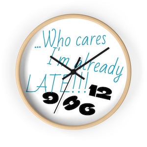 May include: A round wall clock with a light wood frame. The white clock face features black hands, black numbers, and the text "...Who cares I'm already LATE!!!" in blue. The numbers 9, 3, 6, and 12 are in black.