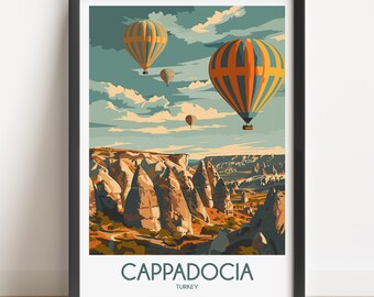 May include: A framed travel poster featuring a landscape of Cappadocia, Turkey, with orange and blue hot air balloons floating above rocky terrain under a cloudy sky. The text CAPPADOCIA TURKEY is printed in dark letters at the bottom.