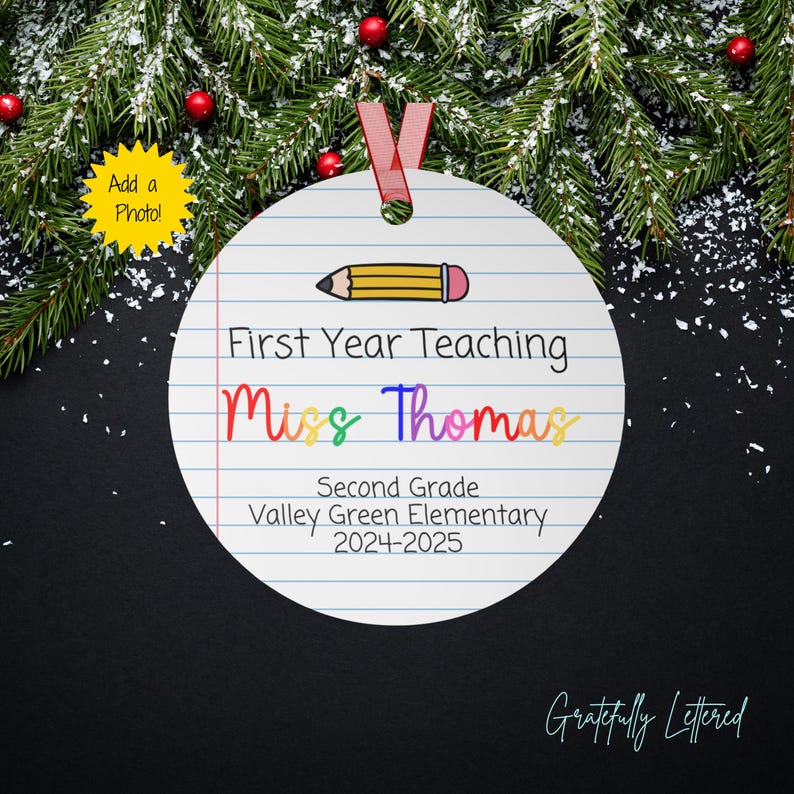 May include: A round white ornament with a lined paper pattern, a yellow pencil graphic, and black text reading First Year Teaching, Miss Thomas, Second Grade, Valley Green Elementary, 2024-2025. The ornament features a red ribbon for hanging.