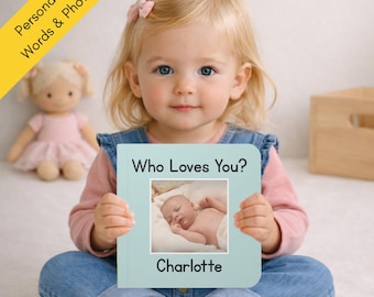 May include: A light blue square board book titled Who Loves You? featuring a central square photograph of a sleeping baby and the name Charlotte printed in black text below the image. A yellow diagonal banner reads Personalize Words & Photos.