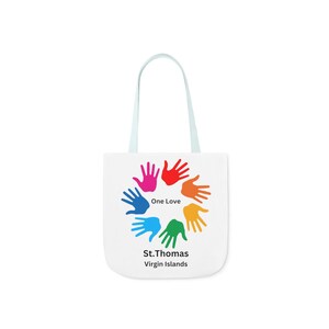 May include: White tote bag with blue handles. The bag features a colorful design of hands in a circle with the text "One Love" and "St. Thomas Virgin Islands".