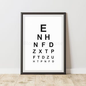 Può includere: Un grafico per la vista incorniciato con lettere nere su sfondo bianco. Le lettere diminuiscono di dimensione dall'alto verso il basso. La cornice è nera, lo sfondo è in legno chiaro.
