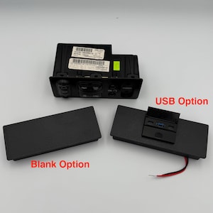 Puede incluir: Panel de control de audio para automóvil negro con botones 'PWR', 'TAPE', 'VOL' y 'PHONES'. Incluye un panel 'USB Option' con un puerto USB y un panel 'Blank Option'. El número de modelo Delco es visible.