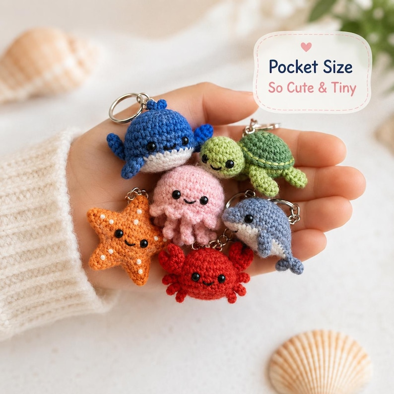 May include: A collection of six small crocheted sea creature keychains including a blue whale, green turtle, pink jellyfish, orange starfish, red crab, and light blue dolphin. Each features black bead eyes and a metal keyring. Text reads Pocket Size So Cute & Tiny.