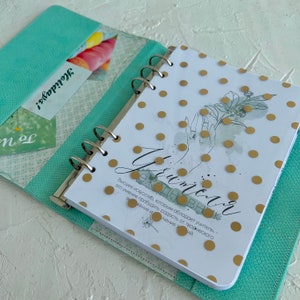 May include: A turquoise planner with a gold polka dot design and a quote about the art of teaching. The quote reads, "The highest art of teaching is to awaken the joy of creative expression and knowledge."