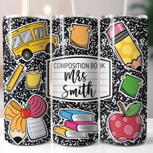 May include: A black and white tumbler with a school theme. The tumbler has a yellow school bus, a pencil, a red apple, a stack of books, a bow, and a notepad. The text on the tumbler says "Composition Book Mrs. Smith".