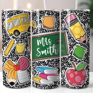 May include: A stainless steel tumbler featuring a black and white composition notebook paper design. The tumbler is decorated with school-themed stickers, including a yellow school bus, a green chalkboard with the name "Mrs. Smith", and a red apple.