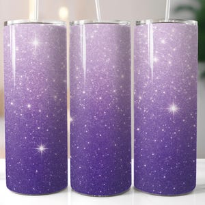 May include: Three stainless steel tumblers with a glittery purple ombre design. The gradient transitions from a deep purple at the base to a lighter shade at the top. Each tumbler has a straw and a starburst design.