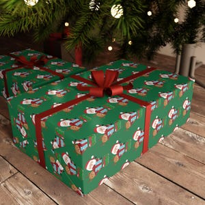 Könnte beinhalten: Grünes Weihnachtsgeschenkpapier mit einem sich wiederholenden Muster aus Weihnachtsmann und Rentieren. Das Papier ist mit einem roten Band gebunden.