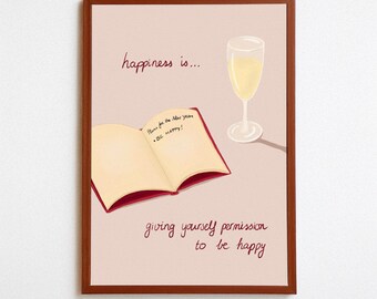 May include: A framed print with a light pink background. The artwork features a champagne glass, an open book with text, and the phrase "happiness is... giving yourself permission to be happy" in a handwritten font.