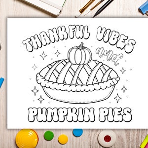 May include: A black and white coloring page featuring a pumpkin pie with the text "Thankful Vibes and Pumpkin Pies".
