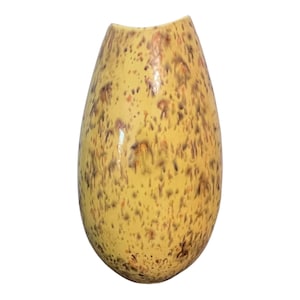 May include: A tall, speckled vase with a yellow base and brown and red spots. The vase has a unique, elongated shape with a curved top. The ceramic vase is a decorative item.
